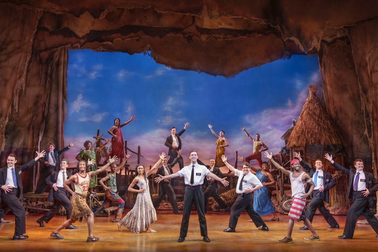 A view of the stage during the Book of Mormon musical. This moment features several mormon boys and several Ugandan locals as they dance with smiles on their faces.